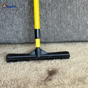 Rubber broom pulling dog hair out of carpet fibers