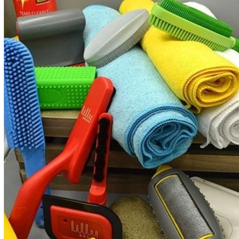 Rubber pet hair remover tool and reusable lint roller placed beside a fabric couch cushion.