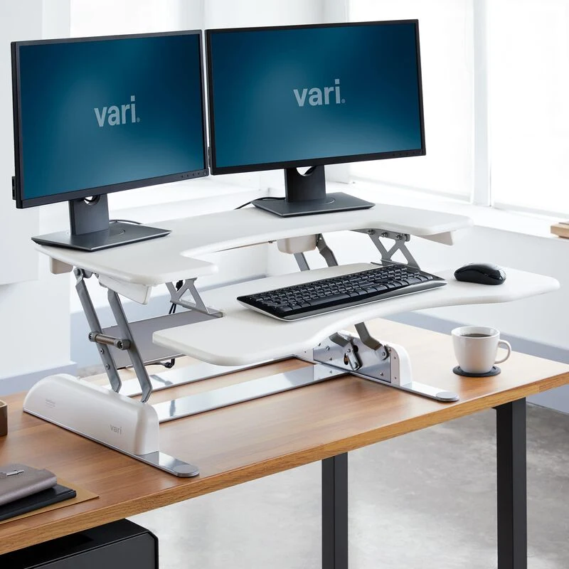 Vari VariDesk Pro Plus 36 standing desk converter with dual monitors raised on a desk