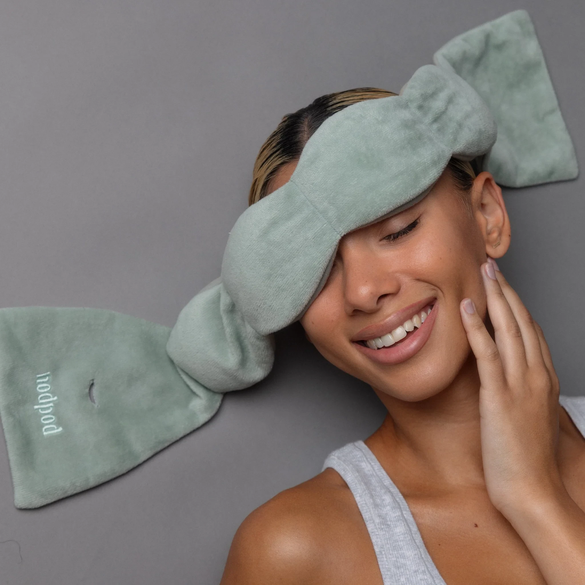 Nodpod weighted sleep mask in sage with four-pod design and long strap-free pull-through strap, logo visible